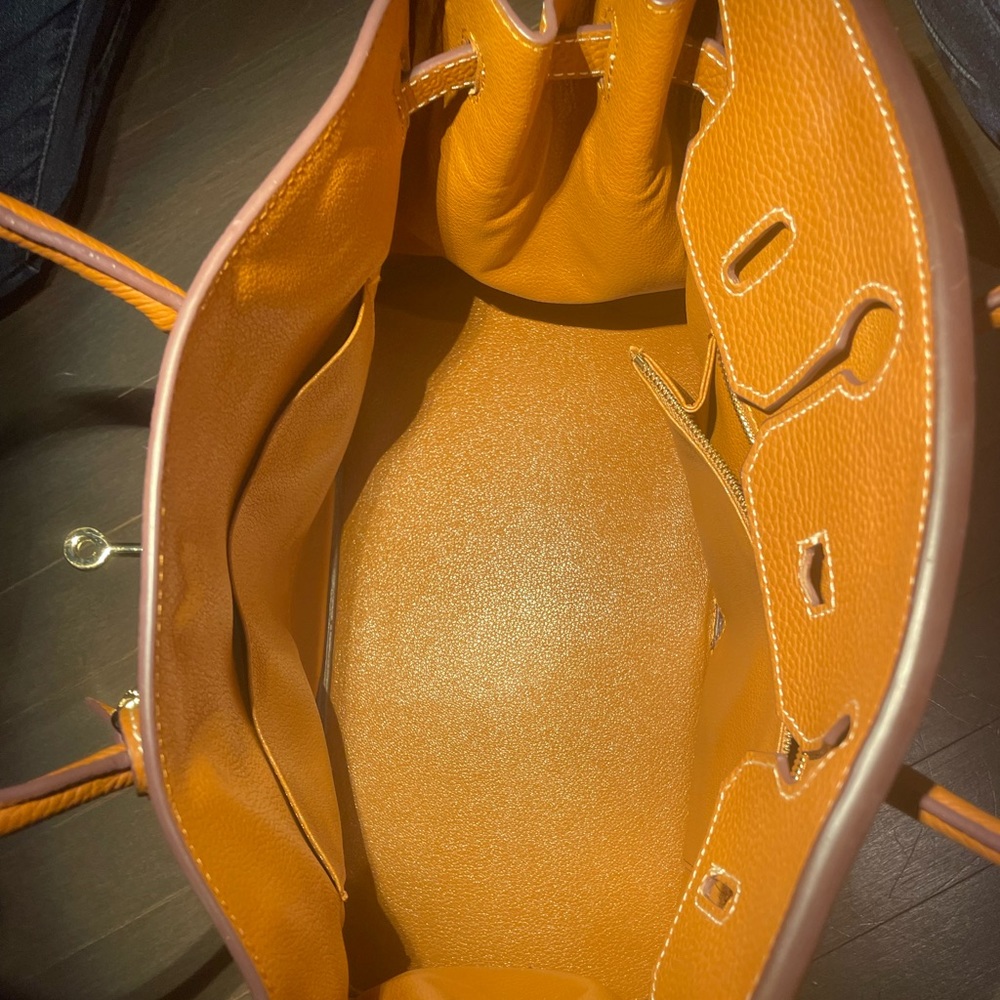 Short, double handle handbag. Tan color. Comes with lock and key. Like new.